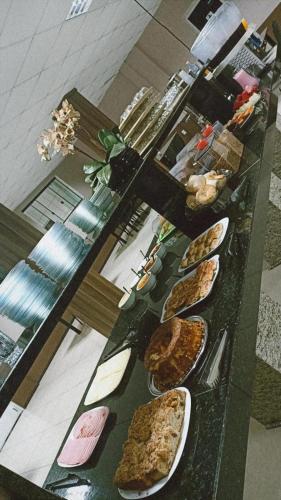a table with several plates of food on it at Hotel Guia lopes in Santa Rosa