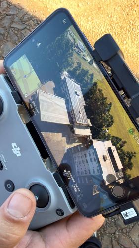 a person holding a video game controller in their cell phone at Hotel Guia lopes in Santa Rosa