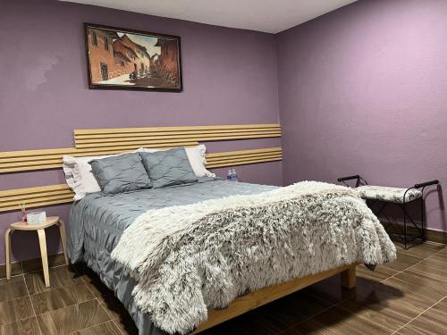 a bedroom with a bed and a painting on the wall at Alojamiento Artemisa in Mexico City