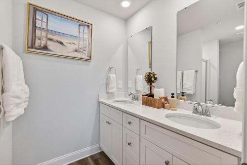 a white bathroom with two sinks and a mirror at Biloxi Coastal Haven Walk to Beach in Biloxi