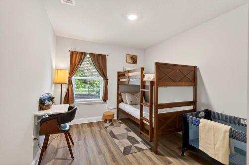 a bedroom with two bunk beds and a desk at Biloxi Coastal Haven Walk to Beach in Biloxi