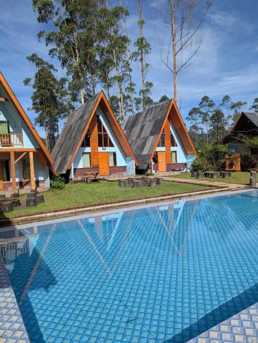 a group of cottages with a swimming pool at Artana cabin in Palayangan