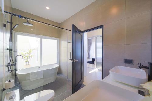 a bathroom with a tub and a toilet and a sink at 3BR Luxury Pool Villa, Hua Hin (TP3) in Hua Hin