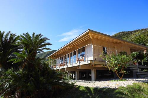 a house on the beach with palm trees in front at Ryukyu Villa - Vacation STAY 11908v in Akaoki