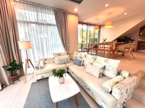 a living room with a couch and a table at Pool Villa at Vimanlay in Cha Am