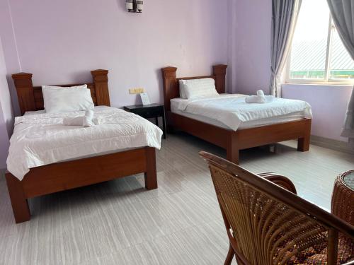 a bedroom with two beds and a window at Ocean Breeze Hotel in Kep