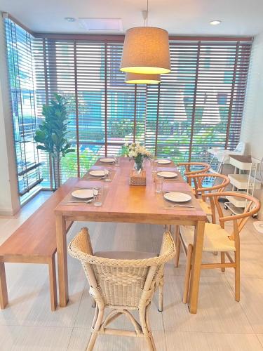 a dining room table with chairs and a large window at Pool Villa at Vimanlay in Cha Am