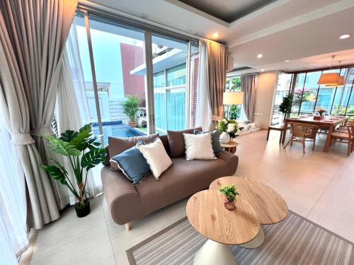 a living room with a couch and a table at Pool Villa at Vimanlay in Cha Am