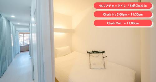 a room with a bed and a sign on the wall at TRANSIT HOSTEL Cafe and Bar in Izumi-Sano
