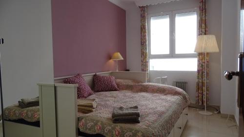 Habitación pequeña con cama y ventana en Cosy Caleta Apartment, en Cádiz