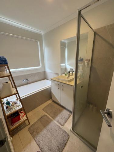 a bathroom with a shower and a sink and a tub at Quiet and Cozy Room in Geelong