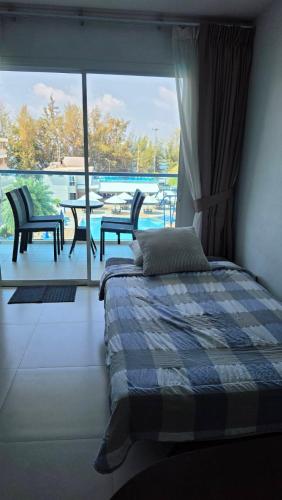 a bedroom with a bed and a view of a patio at Grandblue condominium 405,406 in Ban Tha Fat