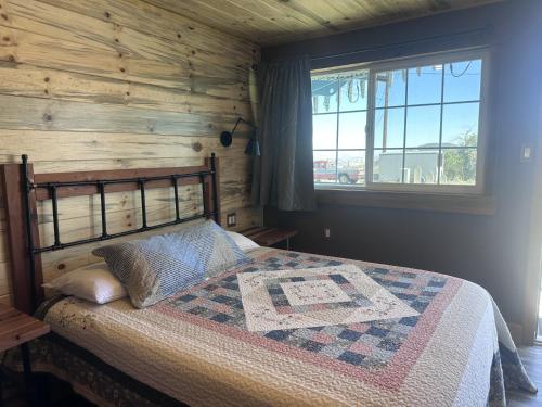 a bedroom with a bed with a wooden wall at Sugarloaf Mountain Motel in Virginia City