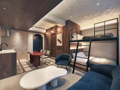 a room with bunk beds and a desk and a couch at illi Noa Hamamatsucho in Tokyo