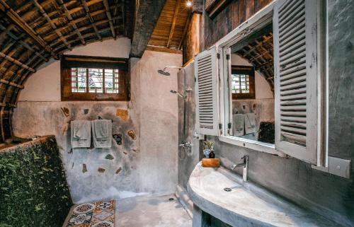 a bathroom with a tub and a sink and windows at Batukaru Coffee Estate in Tabanan