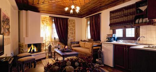 a kitchen and living room with a couch and a fireplace at Aiolides Traditional Homes in Asprangeloi