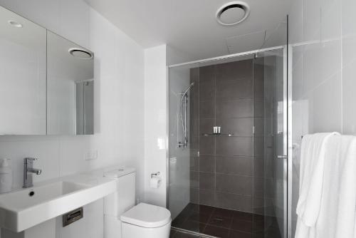 a bathroom with a shower and a toilet and a sink at The Calm in Newcastle