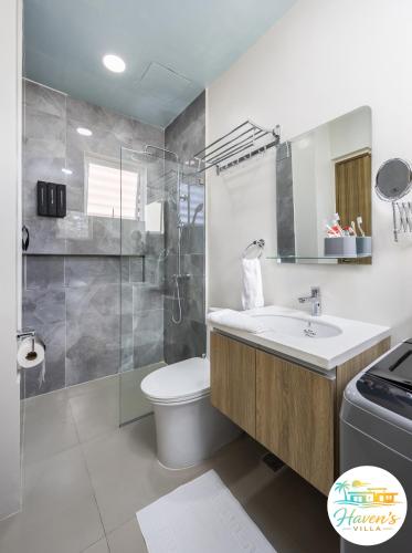 a bathroom with a sink and a toilet and a shower at Haven's Villa in Agus