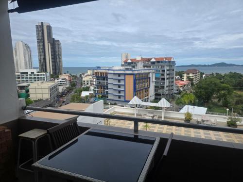 a balcony with a table and a view of a city at Jomtien Hill Resort Pratamnak in Pattaya South