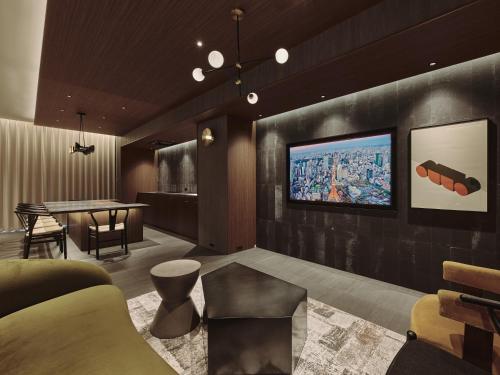 a living room with a television on a wall at illi Gran Azabujuban in Tokyo