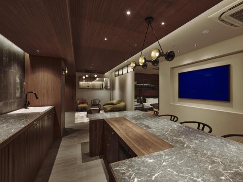 a kitchen with a large counter and a blue screen at illi Gran Azabujuban in Tokyo
