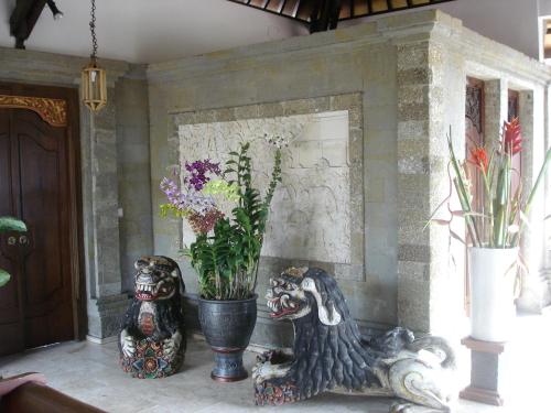 two vases and plants in a room at Tamukami Hotel in Sanur