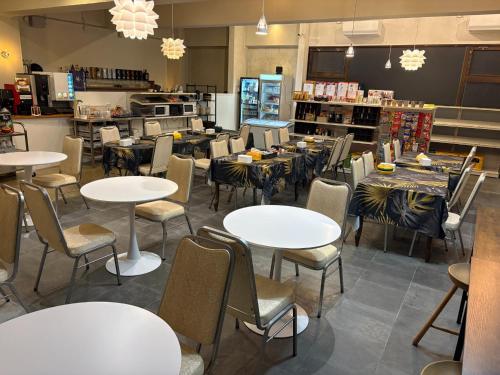 a dining room with tables and chairs and a store at Peace INN Masuda-ekikita in Masuda