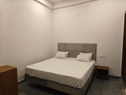 a bedroom with a bed with two pillows on it at Sunrise stay in Mathura