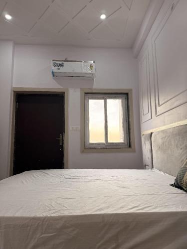 a bedroom with a large bed with a window at Sunrise stay in Mathura