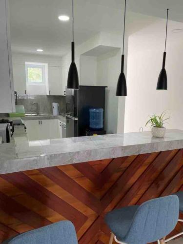 a kitchen with a counter with two blue chairs at OcamOcam Sunset-Bay Guest House in Busuanga