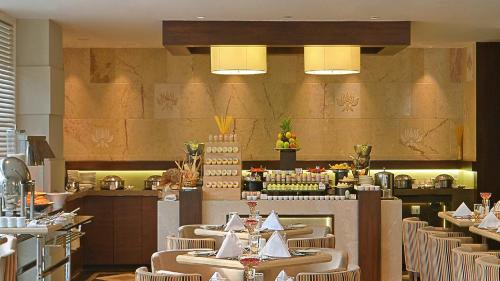 a restaurant with tables and chairs in a room at Country Inns & Suites By Radisson Manipal in Manipala