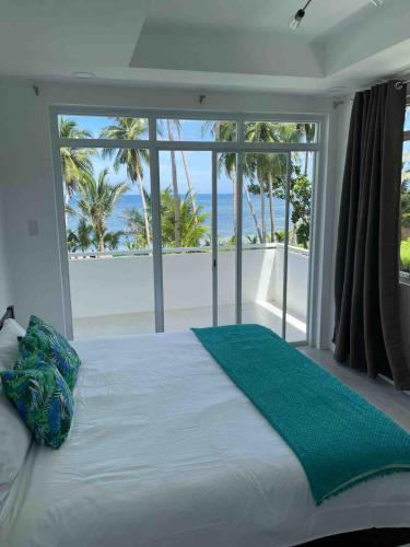 a bedroom with a bed with a view of the beach at OcamOcam Sunset-Bay Guest House in Busuanga
