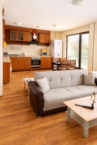 a living room with a couch and a kitchen at Pomorie Sea&History Residence in Pomorie