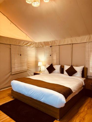 a bedroom with a large bed in a tent at Bandhav Moonlight Resort in Tāla