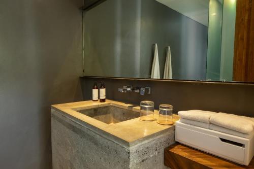 a bathroom with a concrete sink and a mirror at Aria Villas Ubud in Ubud