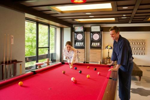 a man and a woman playing pool on a pool table at Kanazawa Hyakurakusou in Kanazawa