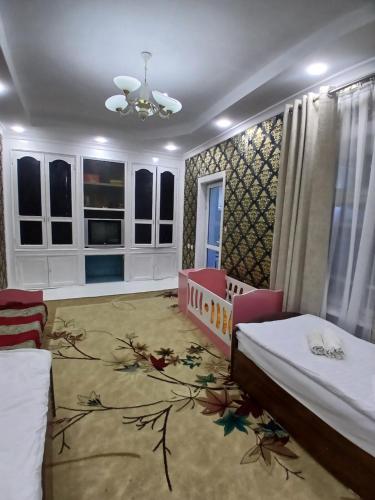 a bedroom with two beds and a crib at Uyut house in Samarkand
