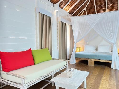 a living room with a couch and a bed at Trikora Beach Club and Resort in Telukbakau