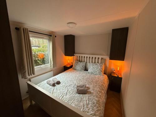 a bedroom with a bed with two stuffed animals on it at VELUWSHOF HOENDERLOO HOLIDAYS Luxe Holidayhomes with PRIVATE JACUZZI'S - SwimmingPool - Tennis Court - Bowling - Supermarket and Children Entertainment in Hoenderloo