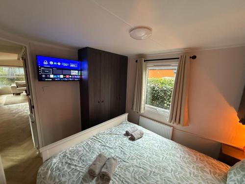 a bedroom with a bed with two towels on it at VELUWSHOF HOENDERLOO HOLIDAYS Luxe Holidayhomes with PRIVATE JACUZZI'S - SwimmingPool - Tennis Court - Bowling - Supermarket and Children Entertainment in Hoenderloo