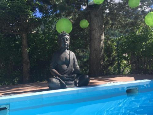 una statua seduta accanto a una piscina con palloncini verdi di Hotel Olympia a Pettneu am Arlberg