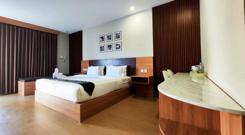 a hotel room with a bed and a desk at Nio Garden Hotel in Sumbawa Besar