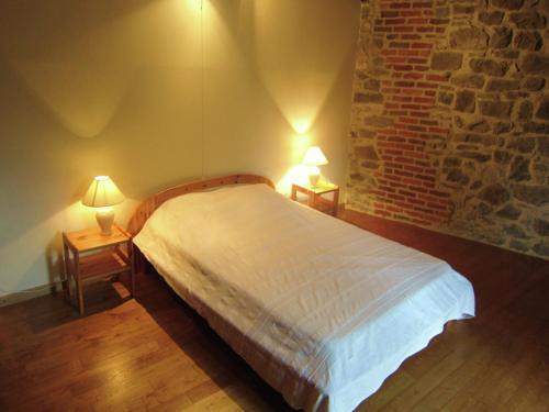 a bedroom with a bed with two lamps on two tables at Riverside Retreat Viroinval in Treignes