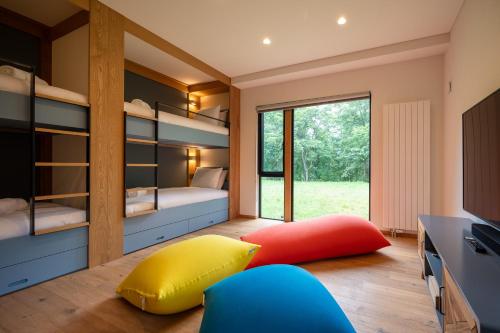 a bedroom with bunk beds and a yellow and red pillow at Shion - 森音 in Kutchan