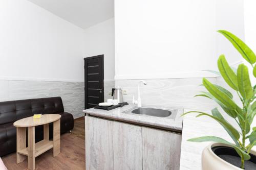 a bathroom with a sink and a couch and a table at Budget Hotel Rooms In Yerevan in Yerevan
