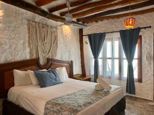 a bedroom with a large bed with blue pillows at Golden Paradise Oceanfront - Self Check in in Holbox Island