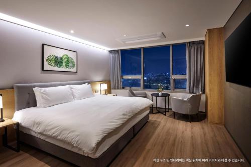 a hotel room with a large bed and a desk at Hotel Interciti in Daejeon