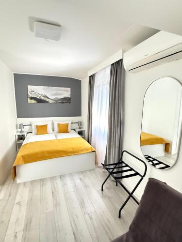 a bedroom with a bed and a mirror and a chair at Olive Depadance in Mostar