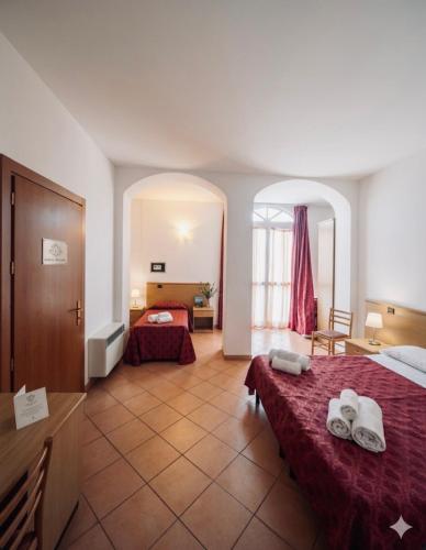 a hotel room with two beds and a bathroom at ALBERGO DELLA STAZIONE in Cairo Montenotte