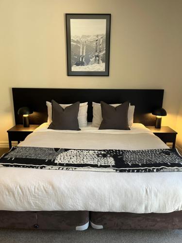 a large bed with a black and white blanket on it at Studio 18 Cardrona in Cardrona